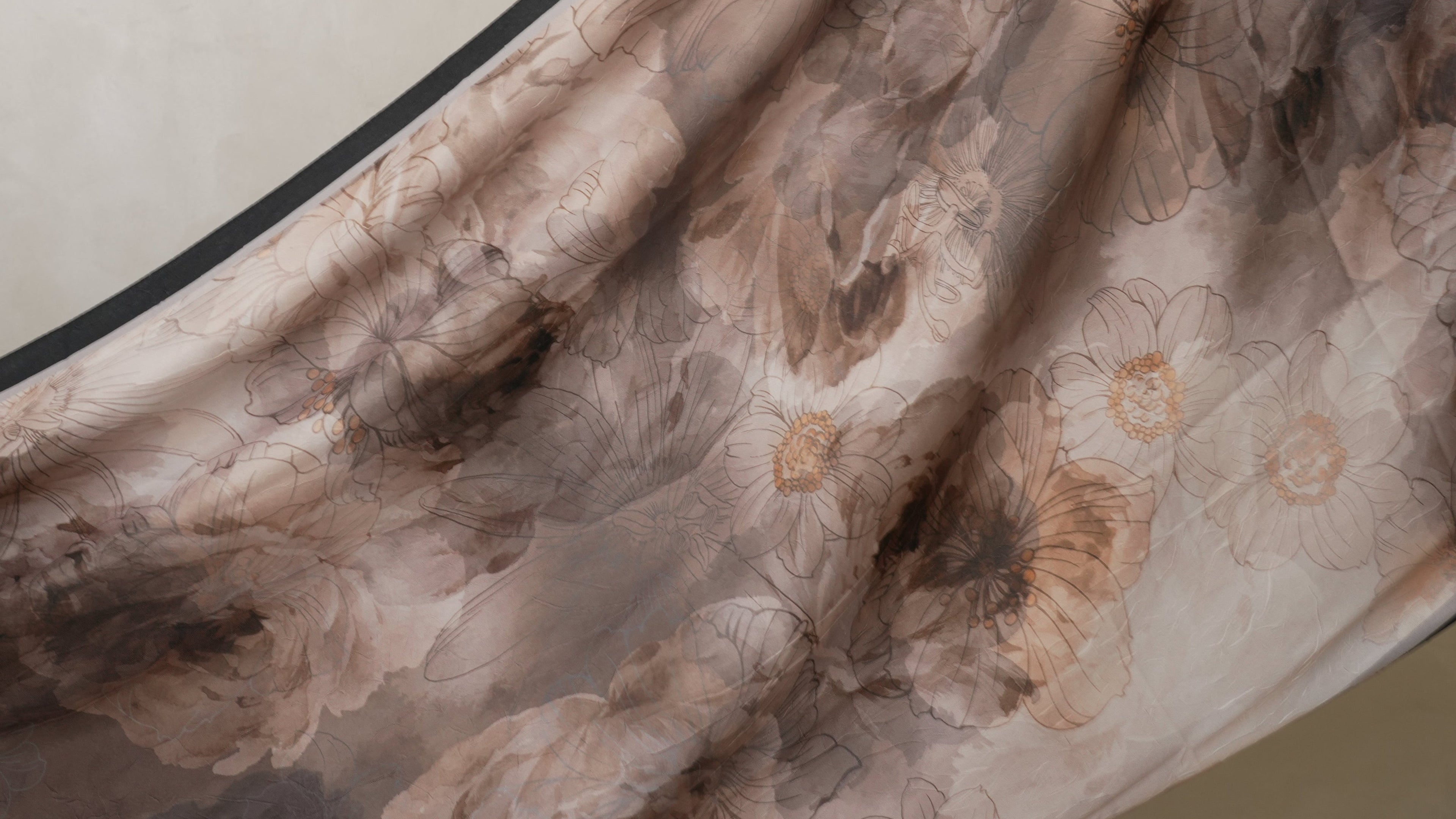 Close-up of floral fabric with a neutral color palette on a beige background